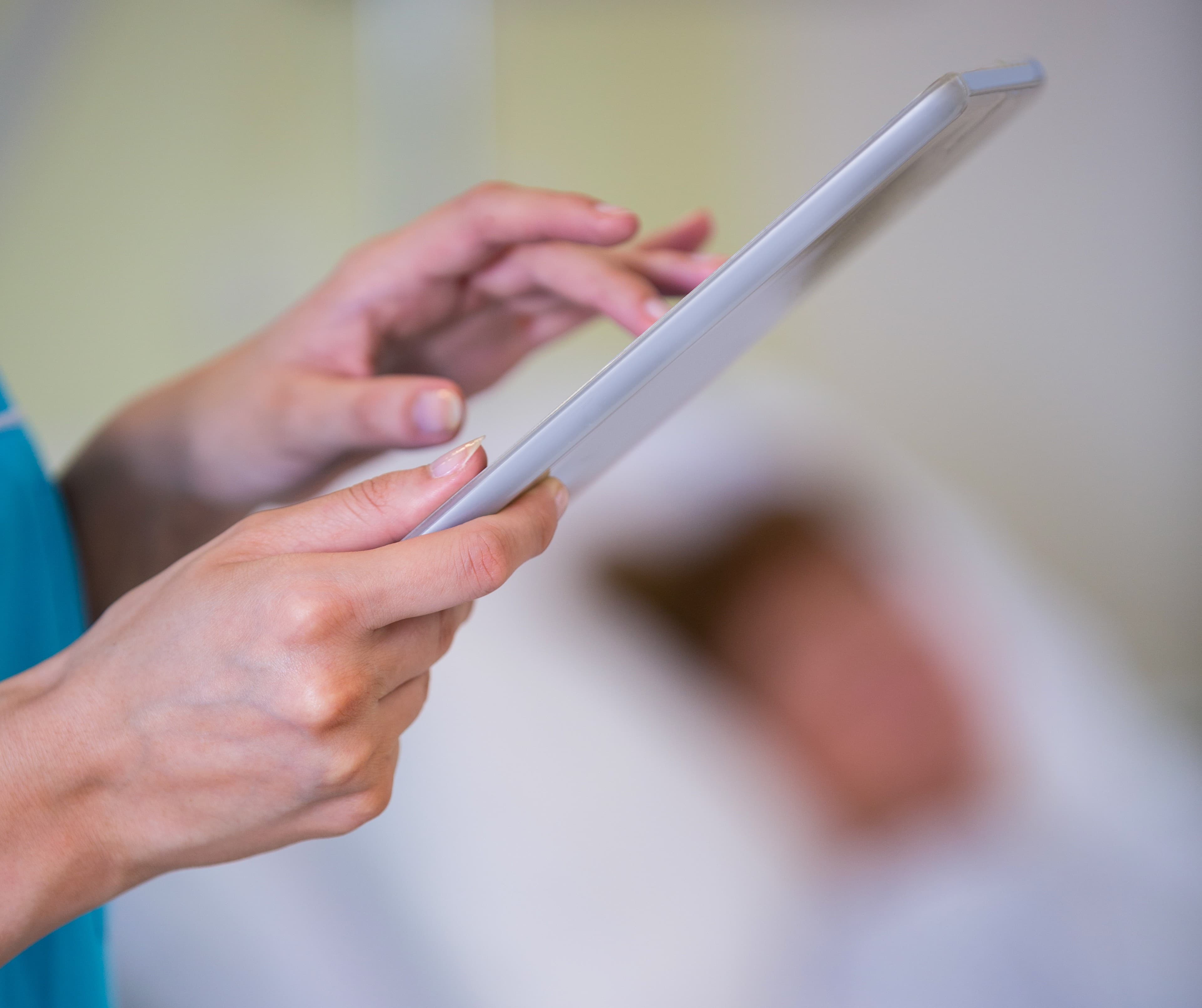 Nurse using digital tablet to manage care home policies
