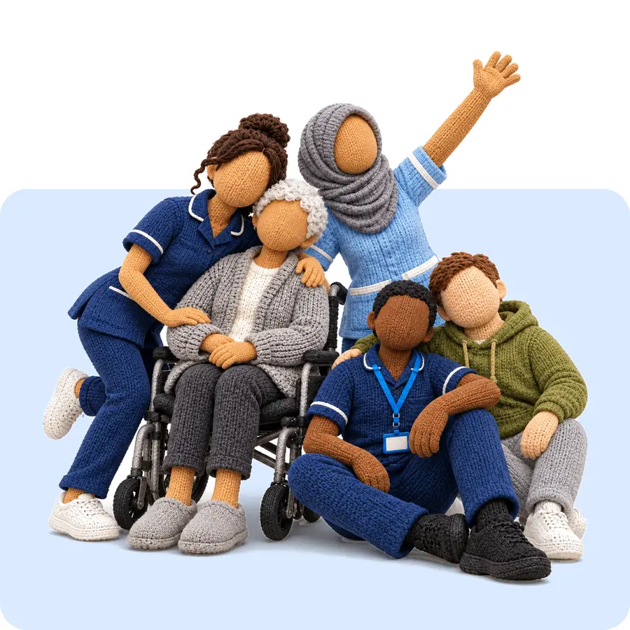 Two nurses, an older woman in a wheelchair, a carer in scrubs and a young man in a hoodie posing together for a group photo, one nurse waving